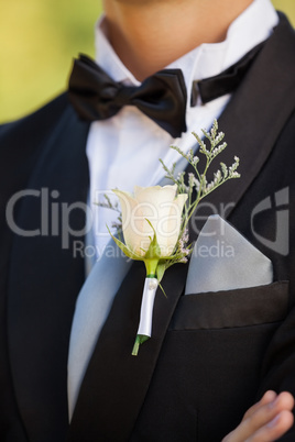 Mid section of flowers on lapel of male