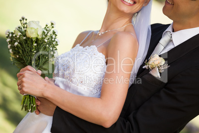 Mid section of happy newlywed couple in park