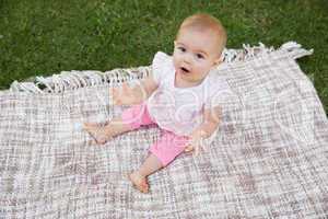 Portrait of a cute baby on blanket at park