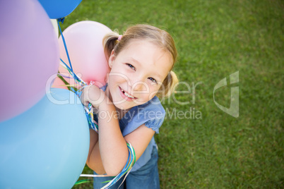 Portrait of a girl with colorful balloons at park