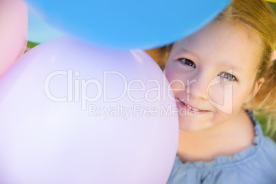 Young girl with colorful balloons at park