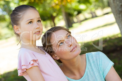 Mother and daughter looking up at park