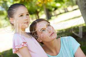 Mother and daughter looking up at park