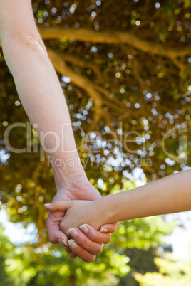 Mother holding a hand of her daughter outdoors