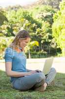 Relaxed young woman using laptop at park