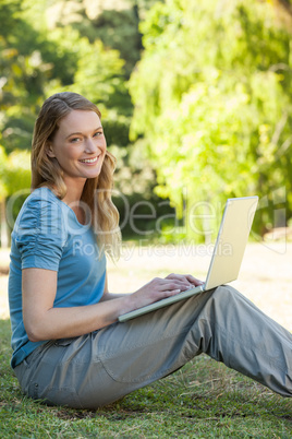 Relaxed woman using laptop at park