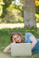 Relaxed young woman using laptop at park