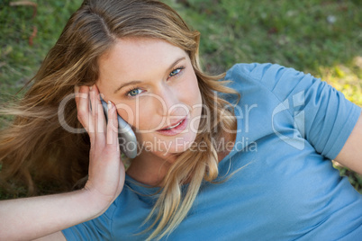 Relaxed woman using mobile phone at park