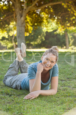 Beautiful relaxed woman lying on grass at park