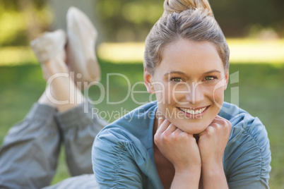 Relaxed young woman lying on grass at park