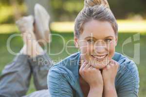 Relaxed young woman lying on grass at park