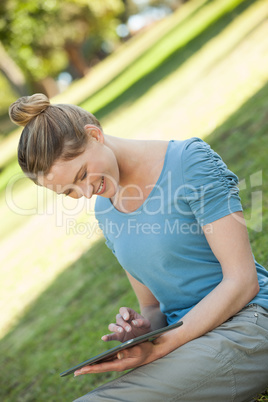 Relaxed woman using digital tablet at park