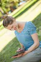 Relaxed woman using digital tablet at park