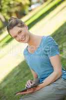 Young woman using digital tablet at park