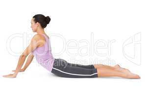 Side view of a fit young woman doing the cobra pose