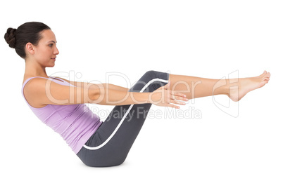 Side view of a fit young woman doing the boat pose