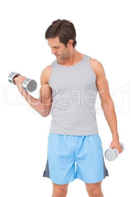 Fit young man exercising with dumbbells