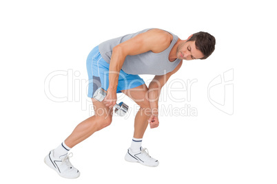 Fit young man exercising with dumbbell