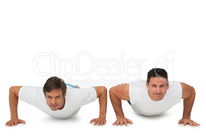 Portrait of two young men doing push ups