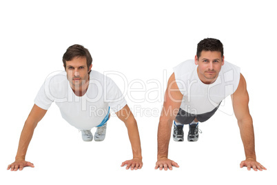 Portrait of two young men doing push ups