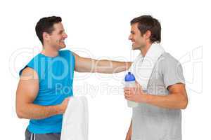 Happy fit young men with water bottle and towels