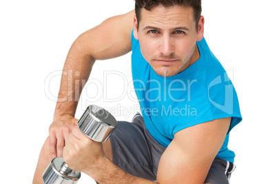 Portrait of a fit young man exercising with dumbbell