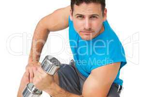 Portrait of a fit young man exercising with dumbbell