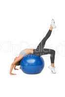 Fit young woman stretching on fitness ball