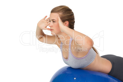 Fit young woman stretching on fitness ball