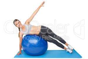 Portrait of a fit woman stretching on fitness ball