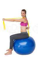 Full length portrait of fit woman exercising on fitness ball