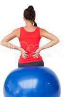 Rear view of a fit young woman sitting on exercise ball