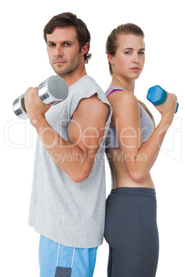 Portrait of a fit couple exercising with dumbbell