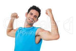 Portrait of a smiling young man flexing muscles