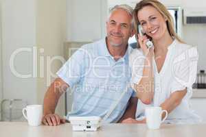 Smiling man listening in on his blonde partners phone call