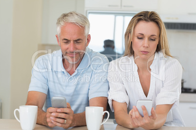 Distant couple sitting at the counter texting and not talking