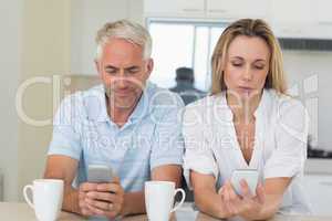 Distant couple sitting at the counter texting and not talking
