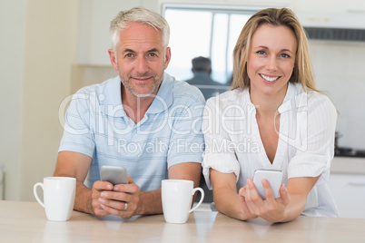 Happy couple sitting at the counter texting