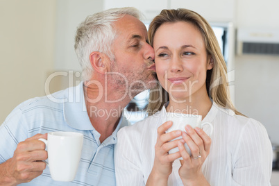 Smiling man giving his partner a kiss on the cheek