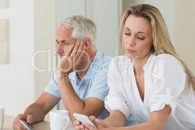 Distant couple sitting at the counter texting