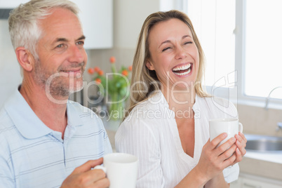 Laughing couple having coffee together