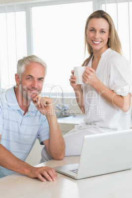 Happy couple using laptop together at the counter