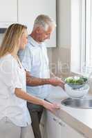 Couple rinsing vegetables at the sink