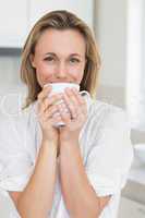 Smiling woman sitting and holding mug