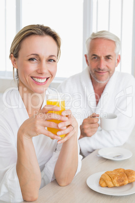Happy couple having breakfast in bathrobes