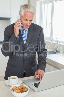 Happy businessman using laptop in the morning before work