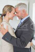 Happy business couple hugging each other before work in morning