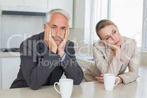 Bored business couple having coffee before work in morning