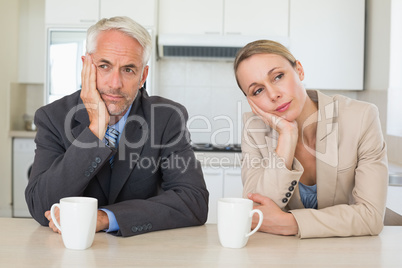 Bored business couple having coffee before work in morning