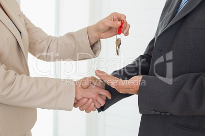 Estate agent giving house key to customer
